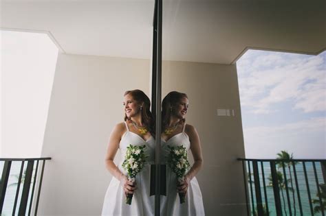 Two Women Standing In Front Of A Mirror With Flowers On Their Wedding Day One Holding Her