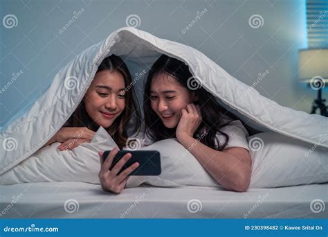 Asian Attractive Lesbian Couple Use Mobile Phone Watch Movie On Bed Beautiful Sibling In