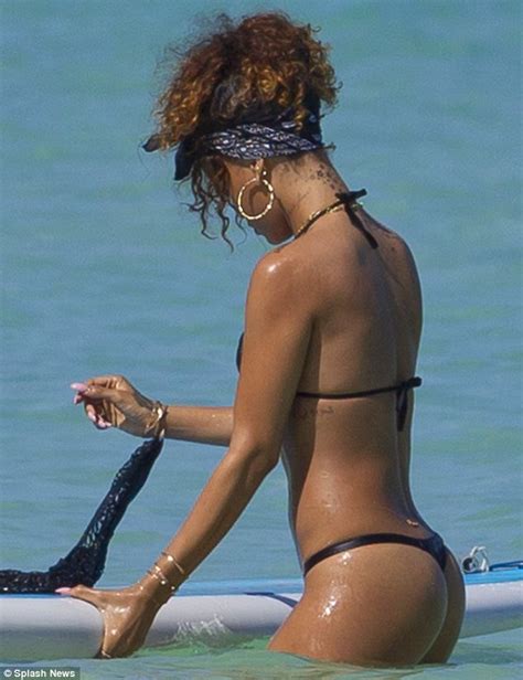 rihanna bares her body in a g string bikini while sunbathing on a surfboard daily mail online