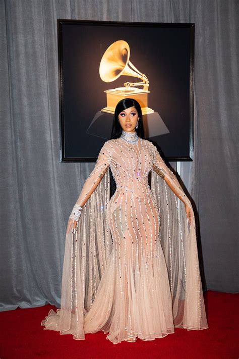 An Image Of A Woman In A Dress On The Red Carpet With Her Hands Behind