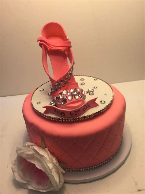 A Pink Cake With High Heel Shoes On Top And A Rose In The Foreground