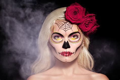 beautiful halloween make up blond model wear sugar skull makeup with red roses day of the dead