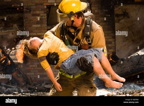 Fire Fighter Rescuing Child Stock Photo Alamy