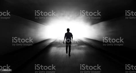 Young Man Walking Through A Dark Tunnel Stock Photo Download Image