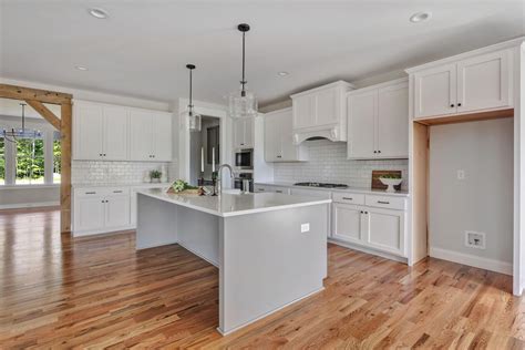 White shaker cabinets with herringbone backsplash and brass hardware. OPEN KITCHEN WITH WHITE SHAKER CABINETS, GRAY ISLAND ...