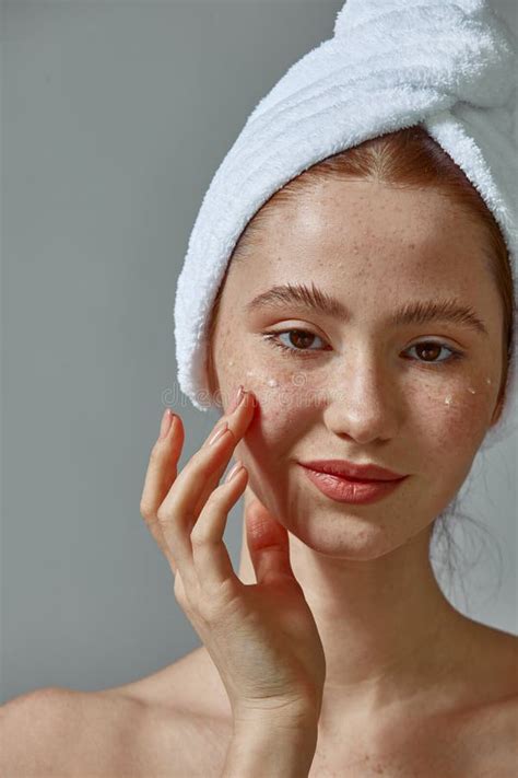 Redhead Young Girl Putting Moisturizing Cream On Face With Freckles For Healthy Skin Around Eyes