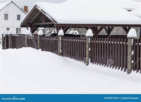 Natural Light Winter A Lot Of Snowdrifts Brown Metal Picket Fence