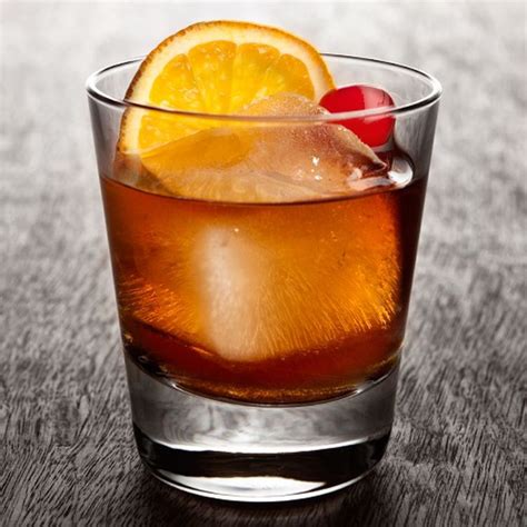 A Close Up Of A Drink In A Glass With An Orange Slice On The Rim