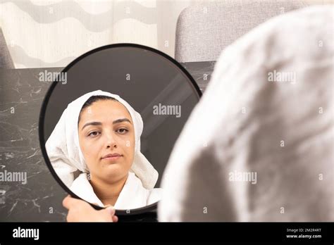 wearing bath towel beautiful woman looking mirror sitting at home doing face massage