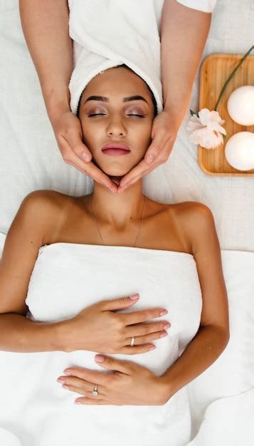 mulher jovem na cama de exame ou na mesa de massagem recebendo um procedimento facial cosmético