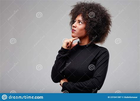 Thoughtful Attractive Young Black Woman Looking Up To The Side Stock