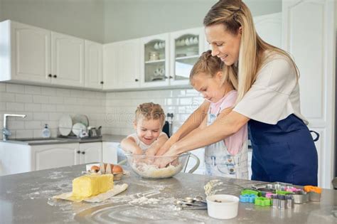 Caucasian Caring Mother And Little Daughters Baking Together In A Kitchen At Home Mom Teaching