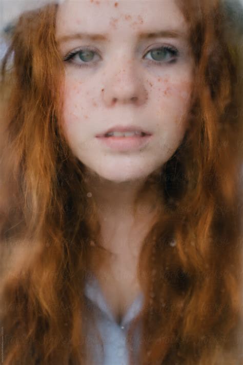 Close Up Of A Ginger Haired Teenager Looking Out Of A Rainy Window By