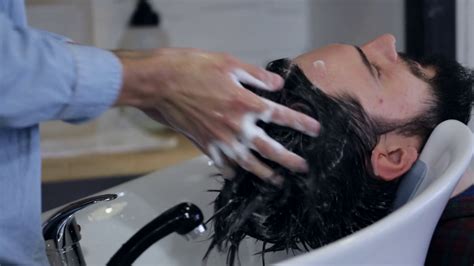 There is no specific time you should wait to wash your hair after getting. Hairstylist washing client's hair in barber shop, close-up ...