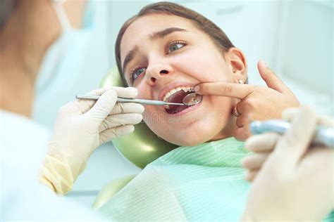 Girl Sitting At Dental Chair With Open Mouth During Oral Check Up While