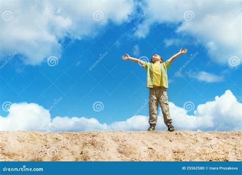 Happy Child Standing With Hands Raised Up Over Sky Stock Photo