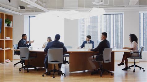 Group Of Business Professionals Meeting Around Table In Modern Office ...