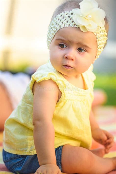 Cute 6 Months Old Baby Girl Infant On A Bed On Her Belly With Head Up