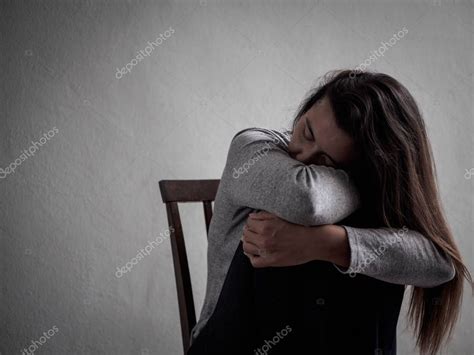 Depressed Broken Hearted Woman Sitting Alone In Dark Room At Home