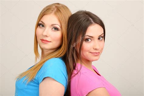 Two Girl Friends Hugging On Grey Background Stock Photo By ©belchonock