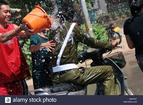 A man is throwing a bucket of water on a policeman on a city street ...
