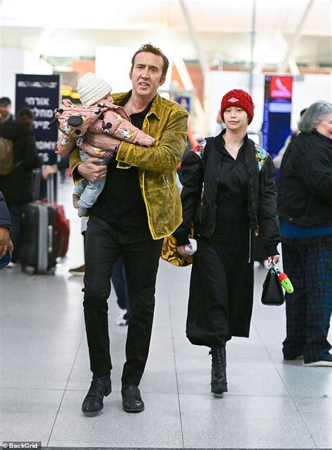 nicolas cage carries daughter august in his arms after he and wife riko shibata touch down at