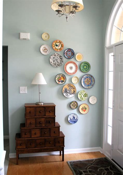 Painted paneled walls are home to an arrangement of vintage racquets, which hang out next to oars, nautical flags, and life preservers. diy wall art from plates - A Pop of Pretty Home Decor Blog