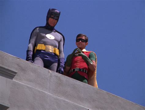 Two Men Dressed As Batman And Robin Wayne Standing On Top Of A Cement