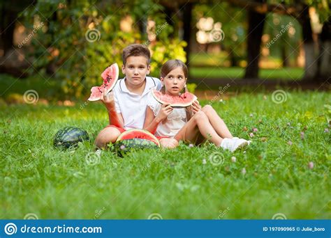 Boy And Girl Sit On The Grass And Eat Watermelon Stock Image Image Of