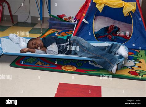 4 Year Old African American Preschool Boy Sleeping On A Cot During