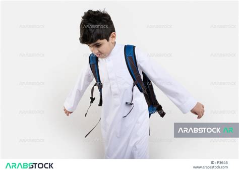 بورتريه لتلميذ عربي خليجي سعودي مبتسم ، يرتدي حقيبة ظهر مدرسية ، و يرتدي الثوب السعودي التقليدي