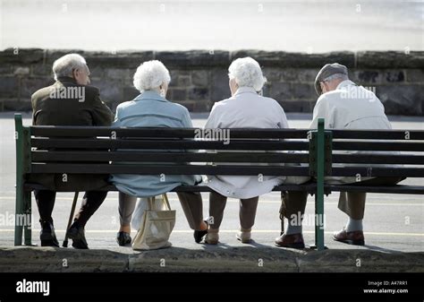 Elderly People Sitting On A Bench On The Sea Front At Weston Super
