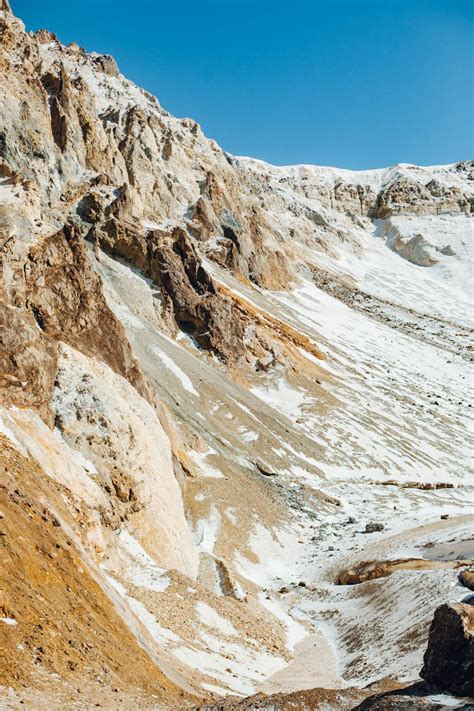 Dry Mountain Slope With Snow Under Blue Sky · Free Stock Photo