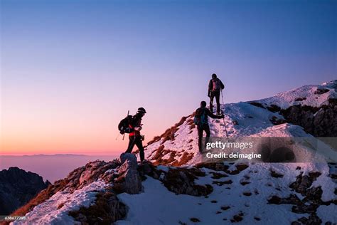 Group Of Hikers Walking On Top Of The Mountain Range High Res Stock
