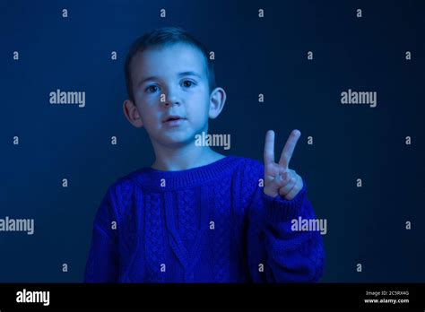 retrato de un niño moreno que cuenta con sus dedos muestra dos dedos tonificando en un clásico