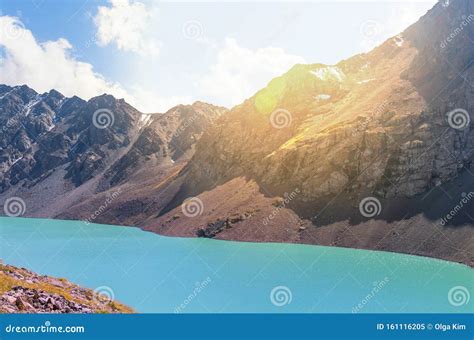 Snowy Mountain Tops And Sun Light Above A Turquoise Lake Stock Image