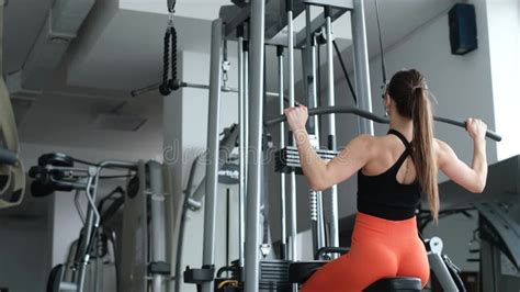 Athletic Woman Trains The Back Muscles In The Gym She Pumps The Main