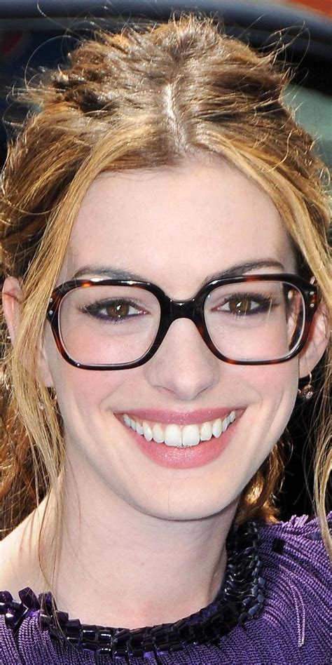 A Close Up Of A Person Wearing Glasses And Smiling At The Camera With Her Hair Pulled Back