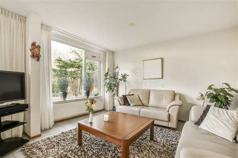 A Living Room With White Furniture And A Large Window Editorial