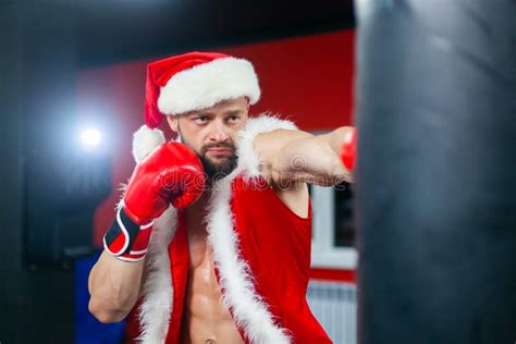 Christmas A Handsome Muscular Man In A Santa Claus Suit With Boxing Gloves Works Out Punches On
