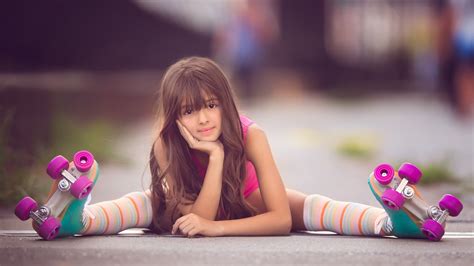 Cute Little Girl Skater Is Sitting On Road Holding Face In Hand In A