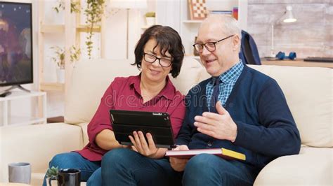 Old Couple Sitting On Sofa During A Video Call On Tablet Stock Image Image Of Laptop Online