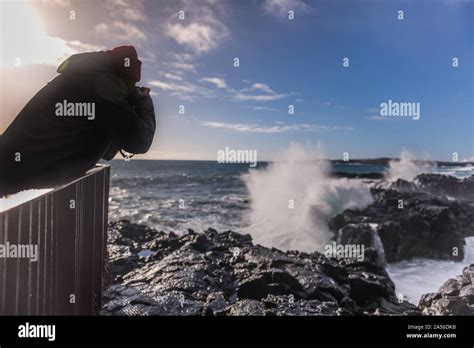 Tourist Photographing Ocean Waves From Pier Reykjanes Iceland Stock