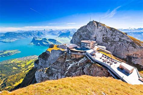 An Aerial View Of A Building On The Top Of A Mountain With Mountains In