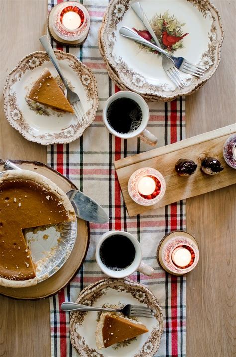A Table Topped With Plates And Cups Filled With Pie