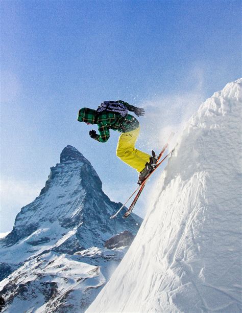 A Man Flying Through The Air While Riding Skis On Top Of A Snow Covered