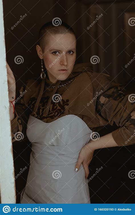 Short Haired Girl In Strange Clothes And Makeup Posing In An Old