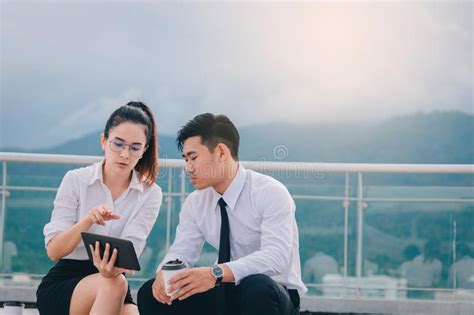 Two Business People Using Digital Tablet At Outside Business Office