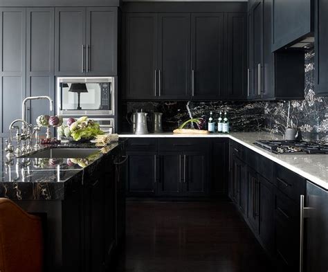 A black dishwater breaks up the white cabinets nicely and compliments the kitchen's color scheme. Noir Kitchen Cabinets with White Marble Countertops - Contemporary - Kitchen