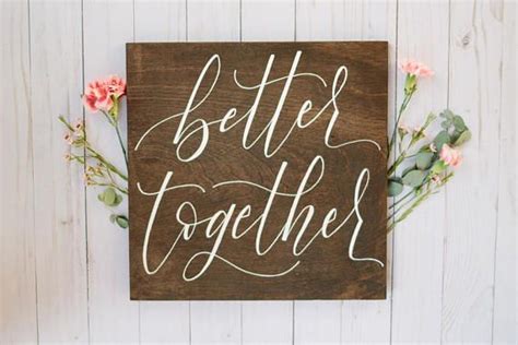A Wooden Sign That Says Better Together With Flowers Around It On A